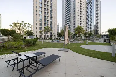 a patio with two tables and an umbrella and buildings at Black & Bold - Aesthetic Stay in Dubai