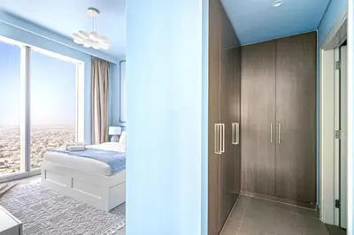 a bedroom with a bed and a closet with a window at KING 2BR LUX Apt-5mins Dubai Mall-Downtown Dubai in Dubai