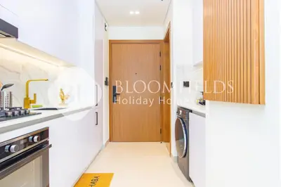 a kitchen with a washer and dryer next to a door at Bloomfields Amber Horizon Stu Binghatti in Dubai
