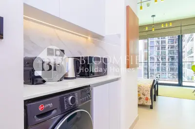 a kitchen with a washer and dryer on a counter at Bloomfields Amber Horizon Stu Binghatti in Dubai