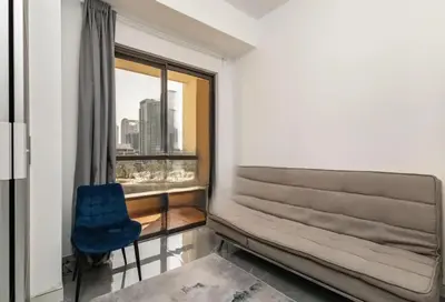 a room with a window and a blue chair at Ahlan Furnished Full Apartment Marina Cityview JBR Beach for Families in Dubai