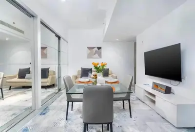 a living room with a table and a tv at Ahlan Furnished Full Apartment Marina Cityview JBR Beach for Families in Dubai