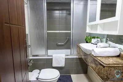 a bathroom with two sinks and a toilet and a shower at 2BR Breathtaking Waterfront Heart of Marina in Dubai