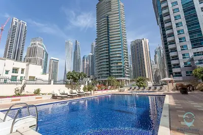 a large swimming pool in a city with tall buildings at 2BR Breathtaking Waterfront Heart of Marina in Dubai