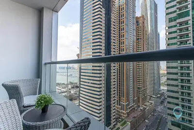 a balcony with a table and chairs and a view of a city at 1BR Modern, Stylish l Mins to Beach l Dubai Marina in Dubai