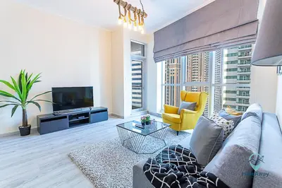 a living room with a couch and a tv at 1BR Modern, Stylish l Mins to Beach l Dubai Marina in Dubai
