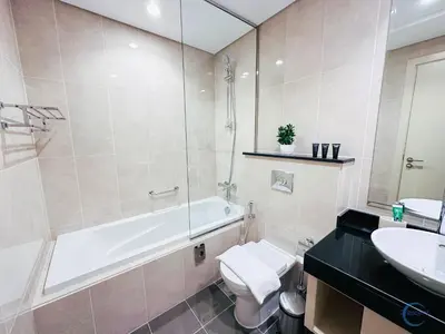 a bathroom with a tub and a toilet and a sink at Luxurious Studio in Damac Hills in Dubai