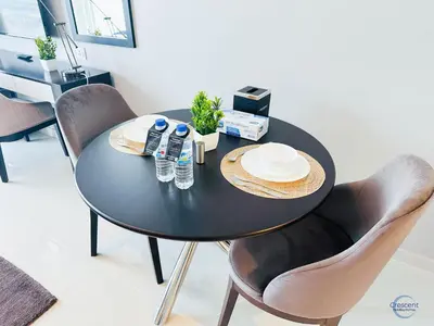 a black dining room table with chairs and water bottles at Luxurious Studio in Damac Hills in Dubai