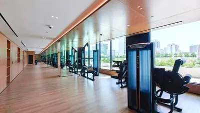 a gym with a row of exercise equipment in a building at Skyline-View 1BR with Balcony,Minutes to Downtown and Marina, Binghatti Onyx, Jumeirah Village Circle by Deluxe Holiday Homes in Dubai
