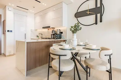 a kitchen with a table and chairs in a room at Skyline-View 1BR with Balcony,Minutes to Downtown and Marina, Binghatti Onyx, Jumeirah Village Circle by Deluxe Holiday Homes in Dubai