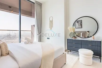 a bedroom with a white bed and a mirror at Skyline-View 1BR with Balcony,Minutes to Downtown and Marina, Binghatti Onyx, Jumeirah Village Circle by Deluxe Holiday Homes in Dubai