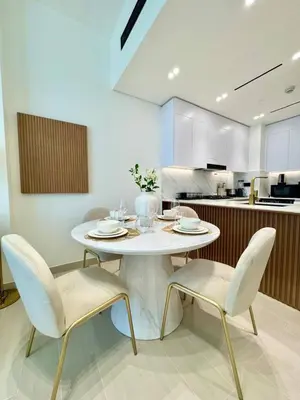 a kitchen with a white table and two chairs at Chic Jvc 1br Pool Access, Balcony & Parking in Dubai