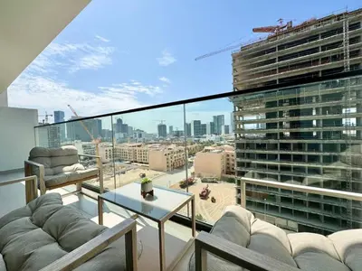 a living room with a view of a large building at Chic Jvc 1br Pool Access, Balcony & Parking in Dubai