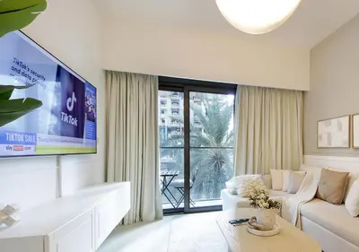 a living room with a couch and a tv at Modern 1BR in Downtown Near Burj Khalifa & Metro in Dubai