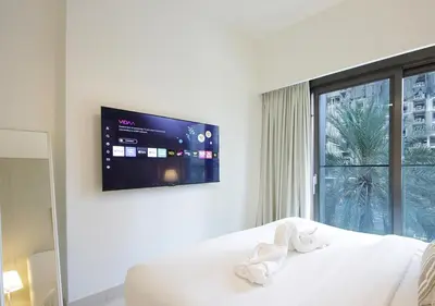 a bedroom with a bed with a tv on the wall at Modern 1BR in Downtown Near Burj Khalifa & Metro in Dubai