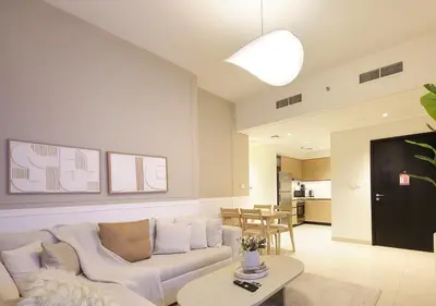 a living room with a white couch and a table at Modern 1BR in Downtown Near Burj Khalifa & Metro in Dubai