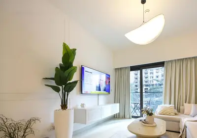 a living room with a couch and a tv at Modern 1BR in Downtown Near Burj Khalifa & Metro in Dubai