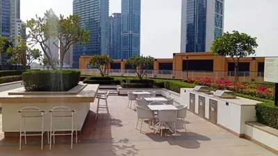 a patio with tables and chairs and a fountain in a city at Modern 1BR in Downtown Near Burj Khalifa & Metro in Dubai