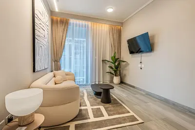 a living room with a couch and a tv at Elegant 1BDR apartment in JVC in Dubai