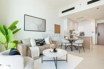 a living room with a couch and a table at High-Rise 1BR with Lake and City Views Easy Access to Downtown and Marina, Binghatti Onyx, Jumeirah Village Circle by Deluxe Holiday Homes in Dubai