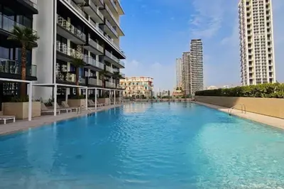 a large swimming pool in the middle of a building at High-Rise 1BR with Lake and City Views Easy Access to Downtown and Marina, Binghatti Onyx, Jumeirah Village Circle by Deluxe Holiday Homes in Dubai