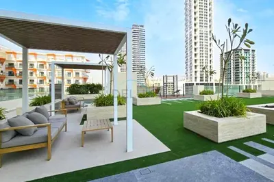 a rooftop patio with furniture and grass at High-Rise 1BR with Lake and City Views Easy Access to Downtown and Marina, Binghatti Onyx, Jumeirah Village Circle by Deluxe Holiday Homes in Dubai