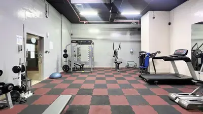 a gym with cardio equipment and a checkered floor at 1BR Beach House Vibes in Prime Marina Location in Dubai