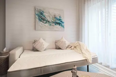 a couch with pillows on it in a room at 1BR Beach House Vibes in Prime Marina Location in Dubai