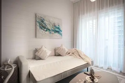 a white couch in a room with a window at 1BR Beach House Vibes in Prime Marina Location in Dubai
