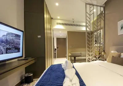 a hotel room with a bed and a flat screen tv at Luxury Damac Studio w Canal View Near Burj Khalifa in Dubai