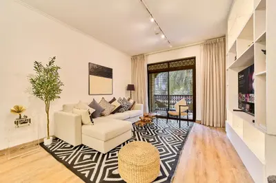 a living room with a couch and a tv at Luxury 1BR in Zaafran With Stunning Burj Khalifa View in Dubai