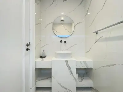 a white bathroom with a sink and a mirror at Luxury 1BR in Zaafran With Stunning Burj Khalifa View in Dubai