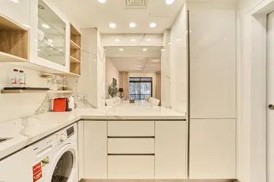 a kitchen with white cabinets and a dishwasher at Luxury 1BR in Zaafran With Stunning Burj Khalifa View in Dubai