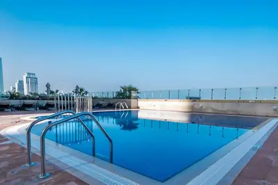 a large swimming pool with a stairway in a building at 1BR Tropical Vibes Near Skydiving and Beach! in Dubai