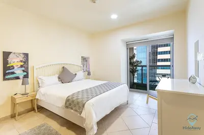 a bedroom with a bed and a large window at 1 BR Blue Chic Dubai Marina, Steps to Beach! in Dubai