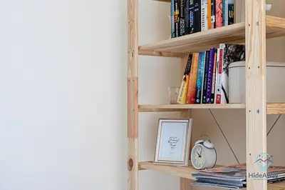 a book shelf with books and a clock at 1 BR Blue Chic Dubai Marina, Steps to Beach! in Dubai