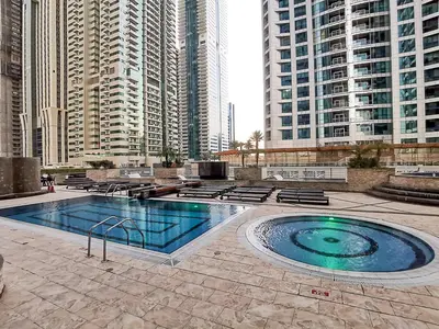 a swimming pool in a city with tall buildings at 1 BR Blue Chic Dubai Marina, Steps to Beach! in Dubai