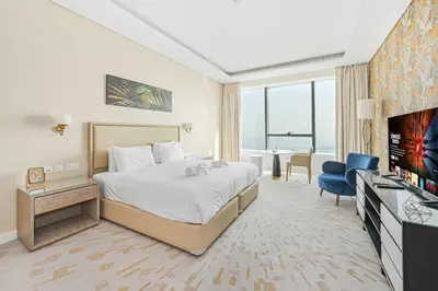 a hotel room with a bed and a flat screen tv at Exquisite studio - Highest at the Palm Tower in Dubai