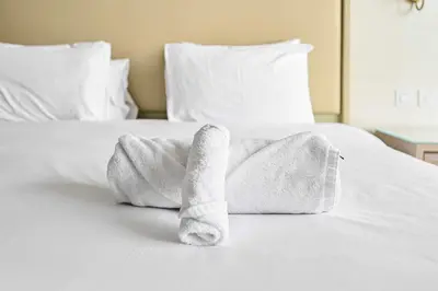 a towel animal is laying on a bed at Exquisite studio - Highest at the Palm Tower in Dubai