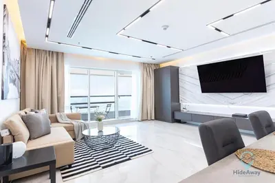 a living room with a tv on a wall at Bright Modern 1BR Heart Of JLT Skyline Views in Dubai