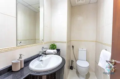 a bathroom with a sink and a toilet and a mirror at 1BR Charming Modern 5Min to Beach Dubai Marina in Dubai