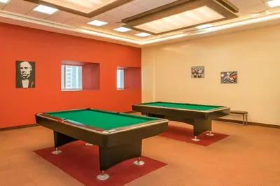 two pool tables in a room with red walls at 1BR Charming Modern 5Min to Beach Dubai Marina in Dubai