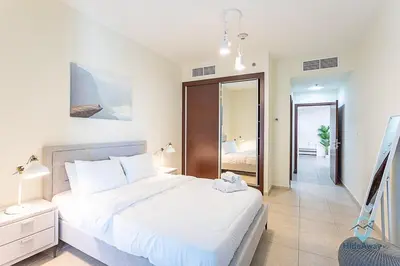 a bedroom with a large white bed and a mirror at 1BR Charming Modern 5Min to Beach Dubai Marina in Dubai