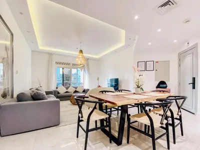 a living room with a table and chairs and a couch at Live the Burj Lifestyle in Timeless OldTown by SBH in Dubai