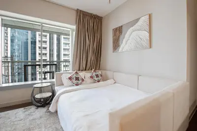 a bedroom with a white bed and a large window at Arabian Nights 1BR - Burj Khalifa & Fountain Views - 5 Mints Walk to Burj Khalifa and Dubai Mall in Dubai