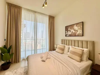 a bedroom with a large bed with a large window at Tranquil 1br Retreat Stylish Stay In Jvc in Dubai