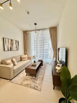 a living room with a couch and a table at Tranquil 1br Retreat Stylish Stay In Jvc in Dubai