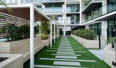 an internal courtyard of a building with grass and plants at Tranquil 1br Retreat Stylish Stay In Jvc in Dubai