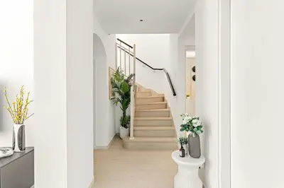 a hallway with white walls and stairs with potted plants at Silkhaus Luxe 2 BDR with Maid room in Springs 7 Villa 14 in Dubai