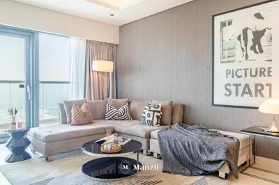 a living room with a couch and a table at Premium 2BR Apartment in Paramount Tower with City Skyline Views in Dubai